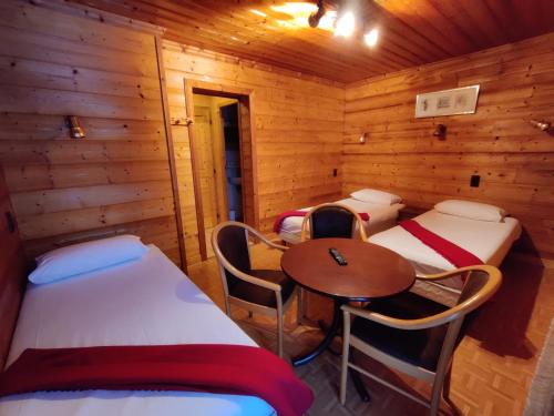 a room with two beds and a table in a cabin at B&B La Seigneurie in Les Gets