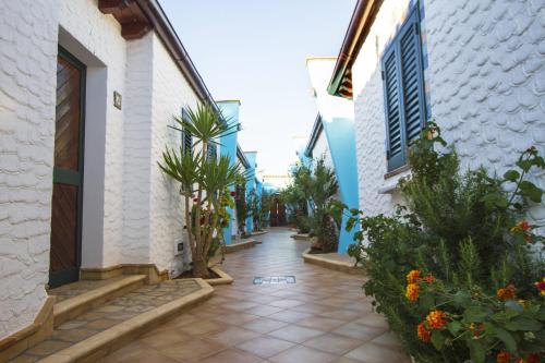 een loopbrug tussen twee gebouwen met planten bij Agriturismo Resort Costa House in Lampedusa