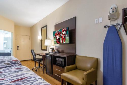 1 dormitorio con cama, escritorio y silla en Red Roof Inn Georgetown, IN - Louisville West, en Georgetown