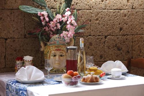 einen Tisch mit einer Vase mit einem Gesicht drauf in der Unterkunft Agriturismo Resort Costa House in Lampedusa