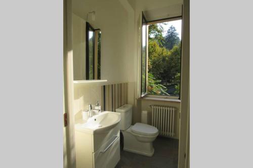 bagno con servizi igienici, lavandino e finestra di Luminoso appartamento in Villa a Stresa a Stresa