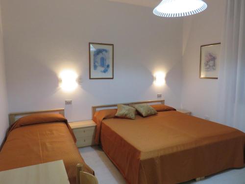 a bedroom with two beds and two lights on the wall at Stella del Mare in Sottomarina