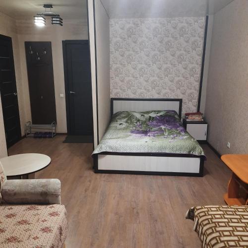 a bedroom with a bed and a living room at Apartment on Plekhanovskaya street 22 in Voronezh