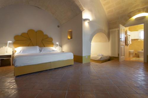 a bedroom with a large bed and a bathroom at Le Dimore Dell' Idris in Matera