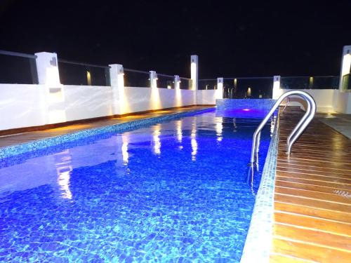 una piscina de agua azul por la noche en Hotel Kavia Plus en Cancún