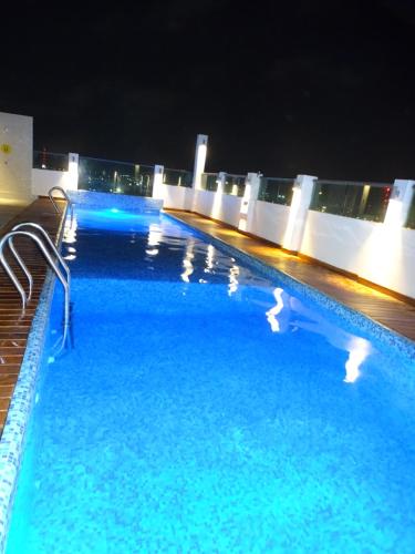een zwembad op de top van een gebouw 's nachts bij Hotel Kavia Plus in Cancun