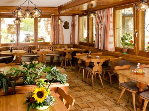 a restaurant with wooden tables and chairs and windows at Hotel Monte-Moro in Saas-Almagell