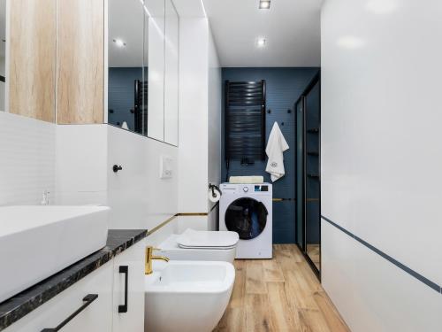 a bathroom with a sink and a washing machine at Apartament Porto Santa Rewales in Rewal