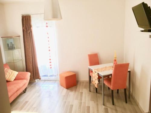 sala de estar con mesa y sillas de color naranja en Cozy 2.5 Apartment with Swimmingpool en Attalens