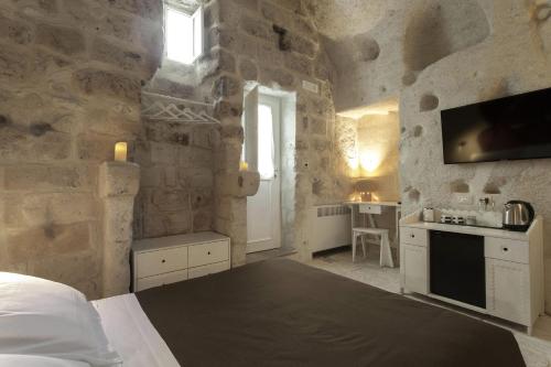 a bedroom with a bed in a stone walled room at Le Dimore Dell' Idris in Matera