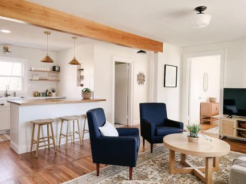 a kitchen and living room with blue chairs and a table at Revived Schoolhouse near Downtown and UT Campus in Knoxville
