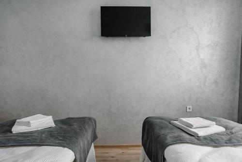 two beds in a room with a tv on the wall at Чевермето-Ірен in Luts'k