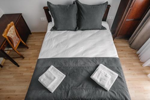 a bed with black and white sheets and pillows at Чевермето-Ірен in Luts'k