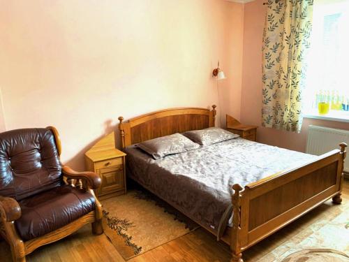 um quarto com uma cama e uma cadeira em Зелений Дім - ViriDi House em Morshin