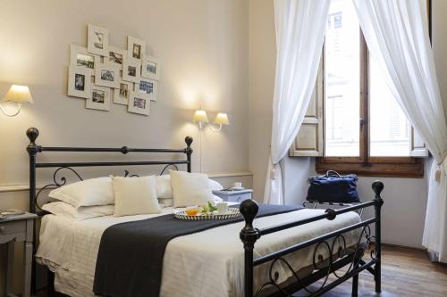 Dormitorio con cama con marco negro y ventana en B&B Prestigia Rooms, en Florencia