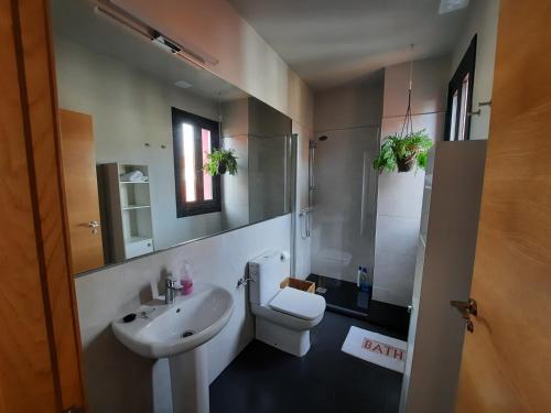 La salle de bains est pourvue de toilettes blanches et d'un lavabo. dans l'établissement Duplex en Casas da Bríxida - Cangas do Morrazo, à Cangas