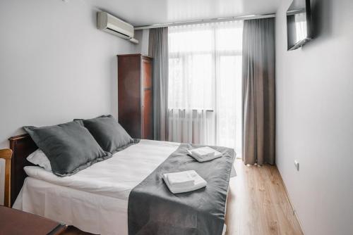 a bedroom with a bed with a table and a window at Чевермето-Ірен in Luts'k