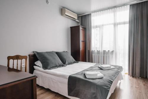 a bedroom with a bed with a desk and a window at Чевермето-Ірен in Luts'k