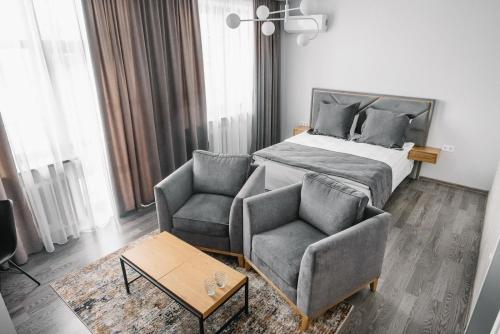 a bedroom with a bed and a couch and a chair at Чевермето-Ірен in Luts'k