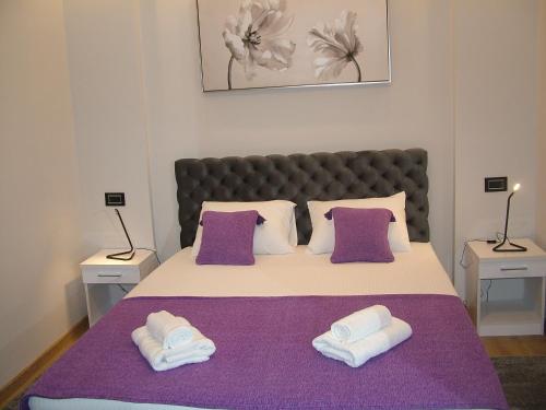 a bedroom with a large bed with two towels at Rose Lux in Belgrade