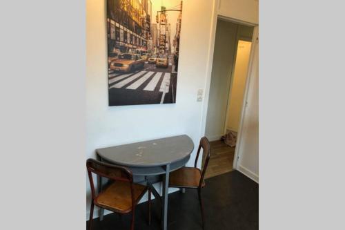 une petite table dans une pièce avec une photo sur le mur dans l'établissement Appartement Caen Hyper Centre, à Caen