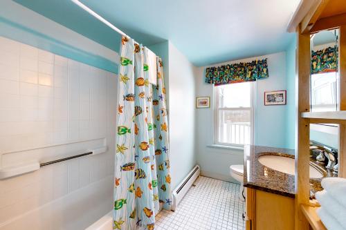 a bathroom with a shower curtain and a sink at Pineapple Paradise in Stowe