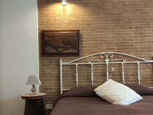 a bed in a room with a brick wall at Antico Podere Il Bugnolo in Poggibonsi