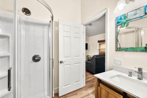 a bathroom with a shower and a sink and a mirror at Sea Cottages of Amelia in Fernandina Beach