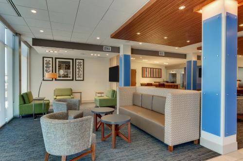 a lobby with chairs and a couch and tables at Holiday Inn Express & Suites - Roanoke – Civic Center in Roanoke
