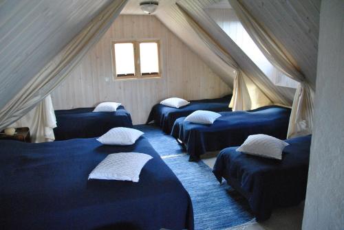 una camera con quattro letti blu in mansarda di Hundi puhkemaja a Hiiumaa
