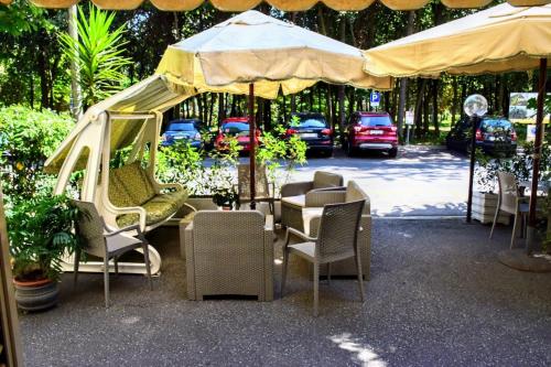 a group of chairs and tables under an umbrella at Hotel Tahiti in Viareggio