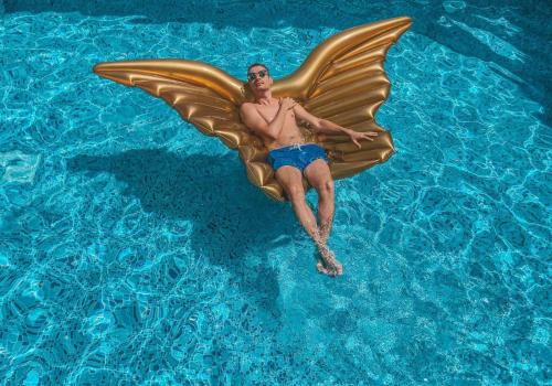 een man met grote vlindervleugels in een zwembad bij Agava Lux Rooms&Pool in Split