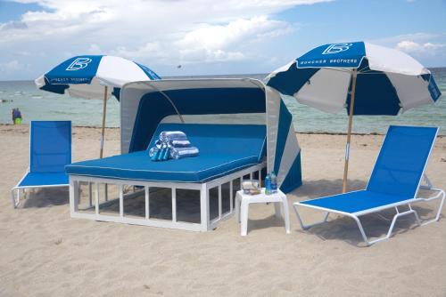 two chairs and an umbrella on the beach at Ocean Reef Suites in Miami Beach