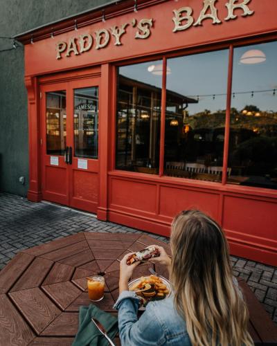 a woman sitting at a table eating food in front of a restaurant at Chateau Elan Winery in Braselton