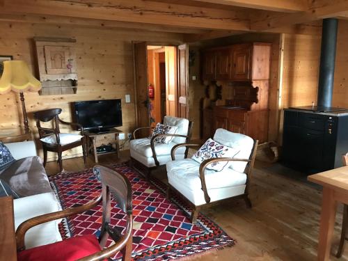 a living room with couches and chairs in a cabin at Chalet Charm in Molare