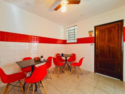 un ristorante con sedie rosse, tavoli e una porta di Pousada Fagundes Varela a Niterói