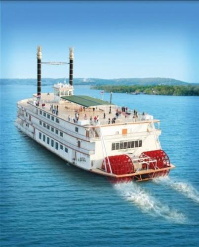 a large boat in the water with people on it at THE BRANSINN Entertainment District in Branson