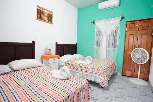a bedroom with two beds and a fan at Hotel y Restaurante Las Gardenias in El Remate