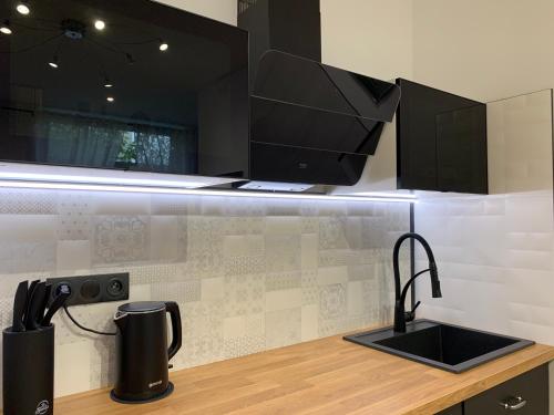 a kitchen counter with a sink and a microwave at Płock by night in Płock