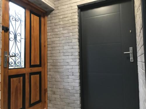 a black door next to a brick wall at Płock by night in Płock