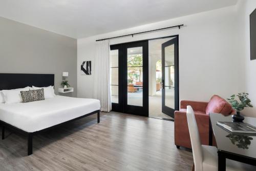 a bedroom with a bed and a living room with a couch at Hotel Casa 425 + Lounge, A Four Sisters Inn in Claremont