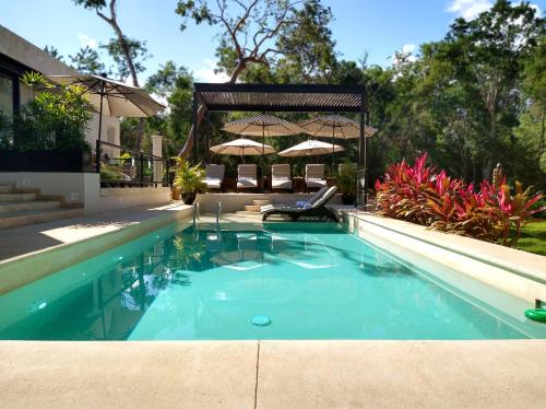 uma piscina com um gazebo num quintal em Xaha Villas Suites & Golf Resort em Tulum