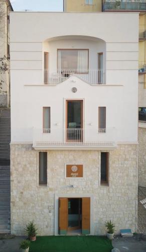 a white building with a balcony on top of it at Bora B&B in Troia