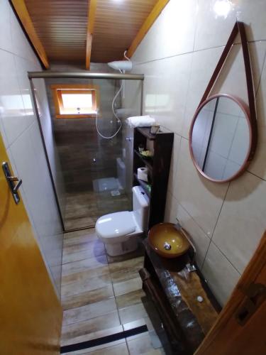a bathroom with a toilet and a mirror at Sossego do Interior in Nova Petrópolis