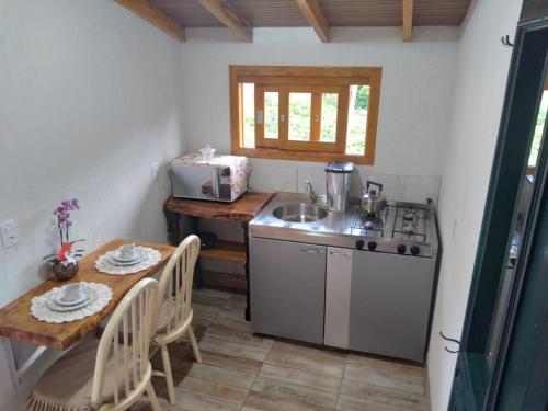 una pequeña cocina con mesa y fregadero en Sossego do Interior, en Nova Petrópolis
