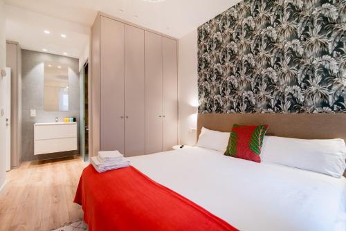 1 dormitorio con cama blanca y manta roja en Liberty Suites by Santiago with AC, en San Sebastián