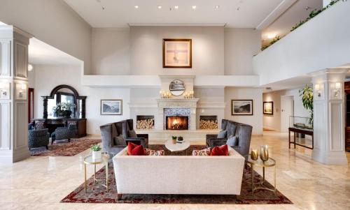 a living room with a couch and a fireplace at Ayres Hotel Costa Mesa Newport Beach in Costa Mesa