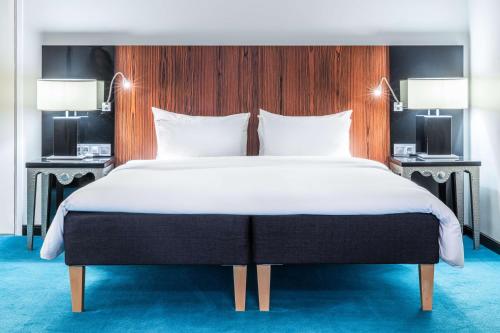a bedroom with a large bed with two lamps at Radisson Blu Hotel Malmö in Malmö