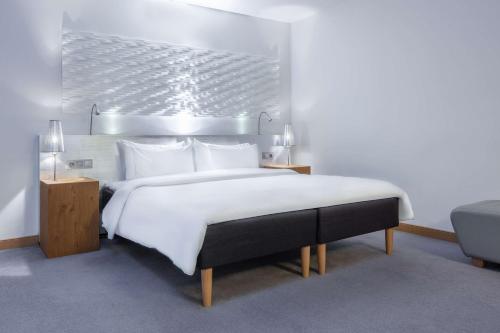 a bedroom with a large bed with white sheets and pillows at Radisson Blu Hotel Malmö in Malmö