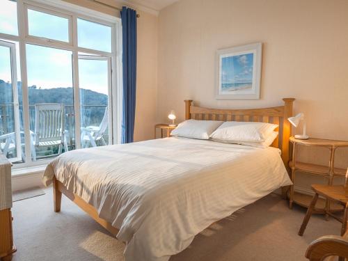a bedroom with a large bed and a large window at 1 Hazeldene in Salcombe